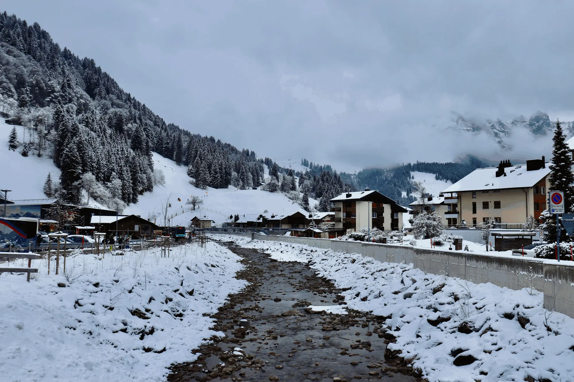 Engelberg village under snow, mountains and river in view
